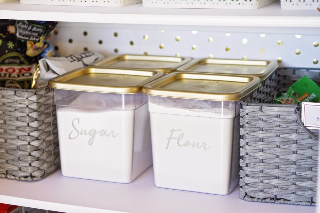 plastic storage bins to store baking ingredients on the pantry floor